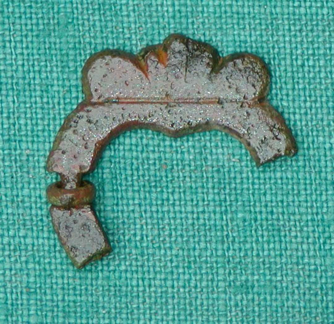 Fragment af hjerteformet ringspænde med simpel 'krone'-udsmykning foroven. 21x25mm.
