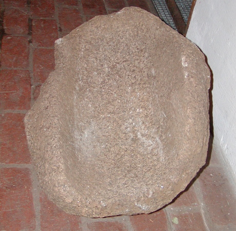 Komplet skubbekværn af bjergart ('granit'). Målet ca. 67x50x30 cm. Kraftig hulning, ca. 14 cm dyb og 31 cm bred. Fortsætter ud gennem den ene ende af stenen.