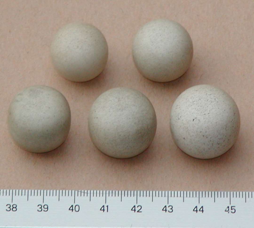 Fem næsten cirkulære glatte sten, tydeligvis forarbejdede. Der kan være tale om vægtlodder. Loddernes vægt:  10.25 g,  12.26 g,  13.73 g,  16.22 g  og  18.21 g Forarbejdet af lys gråhvid finkornet sten. Næsten kugleformede, dog med svagt, flade poler. Datering?