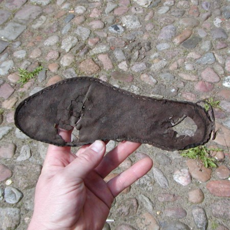 Komplet skosål slidt gennem under hæl og forfod. Længde 23,8 cm.analyse: hjortedyr (bovid/cervid).