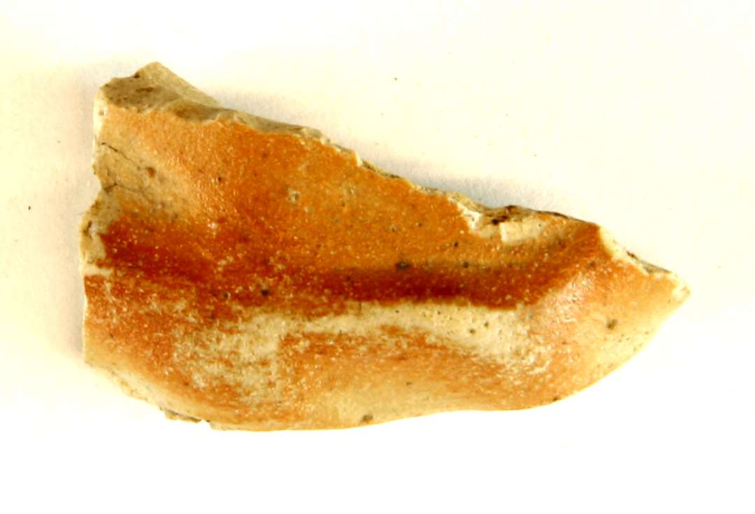 1 fragment fra den bølgende fodrand på kar ( kande ) af finslemmet gråbrændt stengods med tynd brun bemaling og svage spor af saltglasur på ydersiden, gruppe 3.