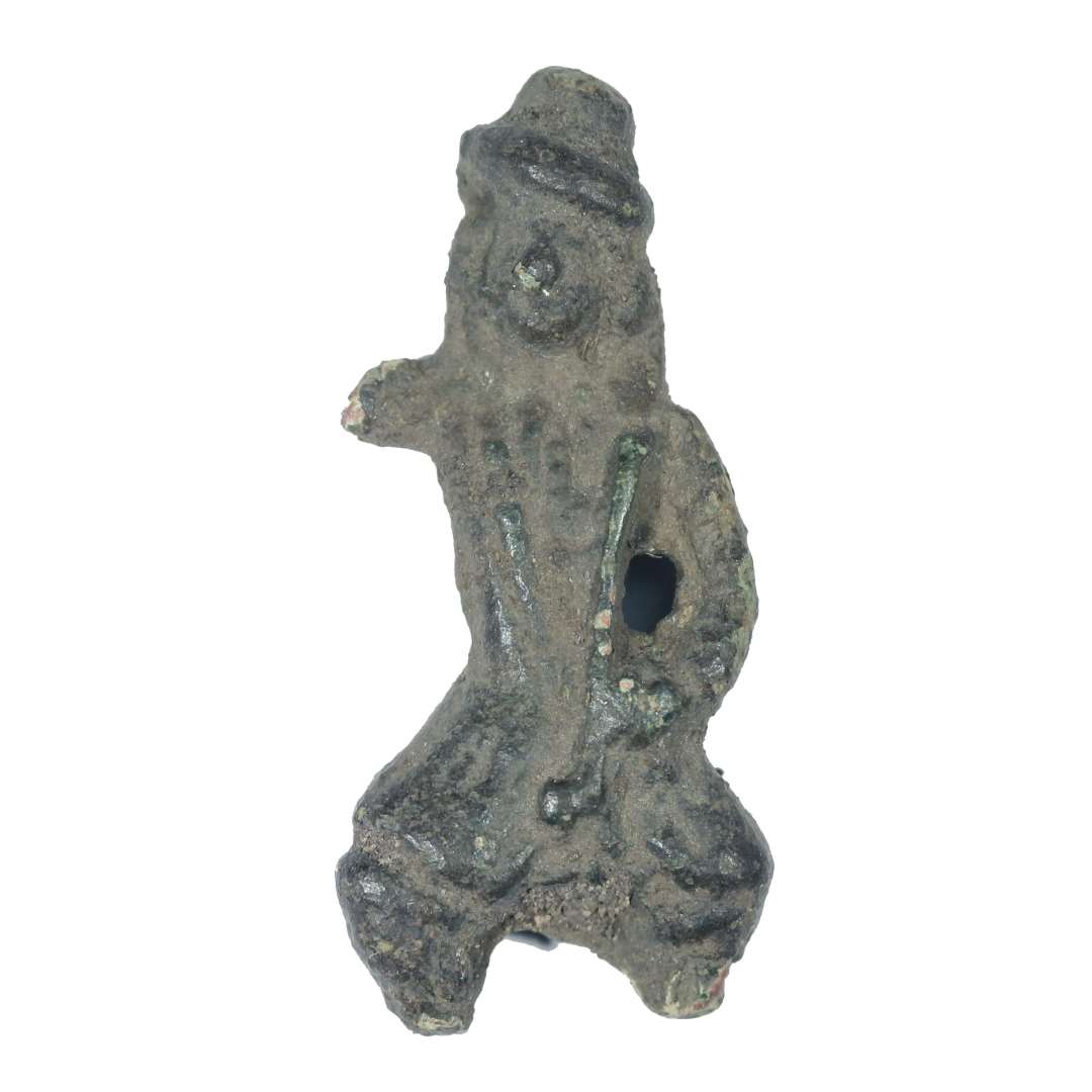 Fragment af legetøjsfigur forestillende en lille mand i 1700-tals dragt: Lang frakke, knæbukser, hat, langt hår, lang pibe. Den ane arm og underbenene mangler. Højde: 3,1 cm., bredde: 1,5 cm.