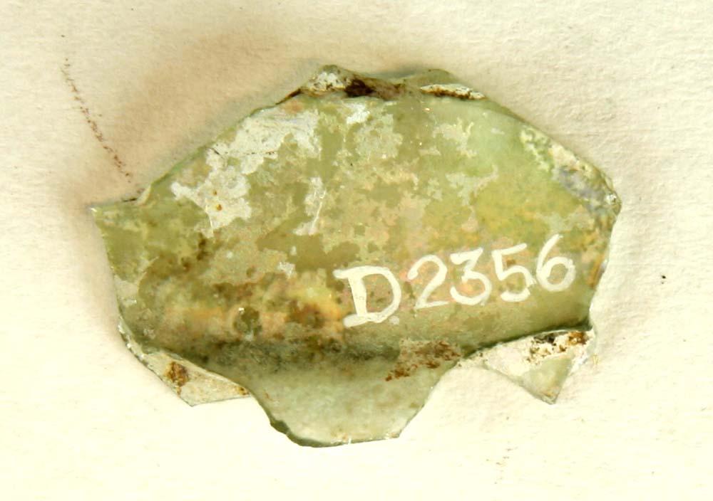 Fragment af foden på drikkeglas, såkaldt ' Stangenglas ' bestående af to delvis sammensmeltede tynde let hvælvede glasplader. Mål: 3,3x2,4 cm.