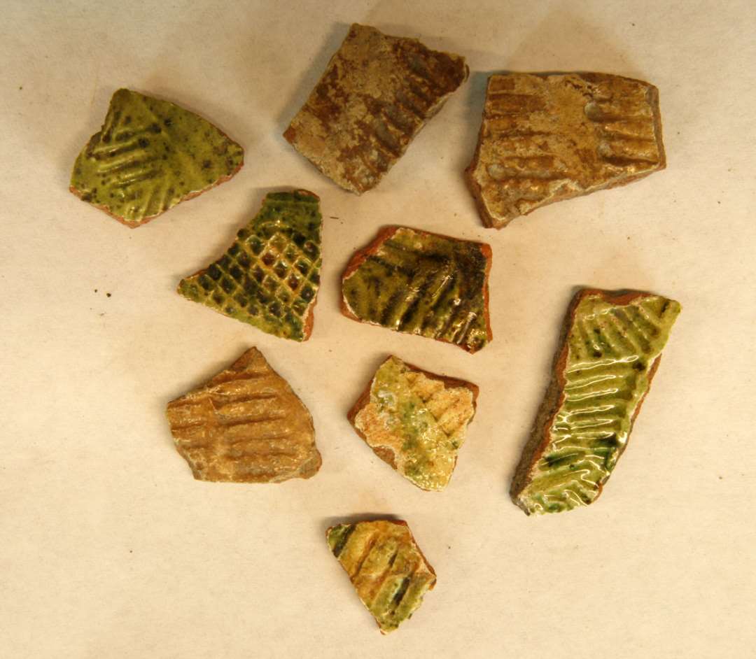 9 sideskår af kander med rullestempel 3 med klar og 6 med grøn blyglassur, B2.