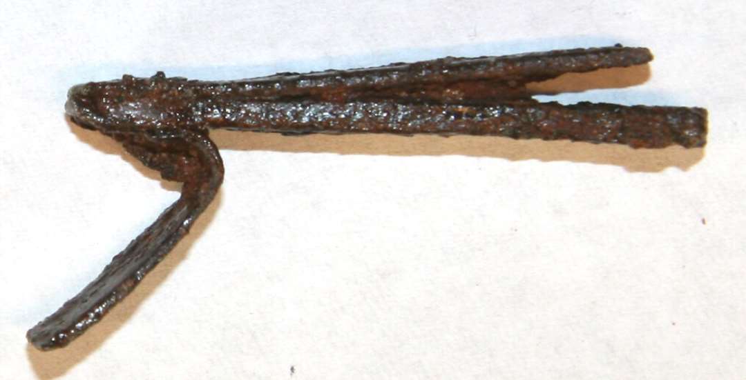 Fragment af låserigel af jern med spor efter lodninger med CU. Største længde 3,8 cm.