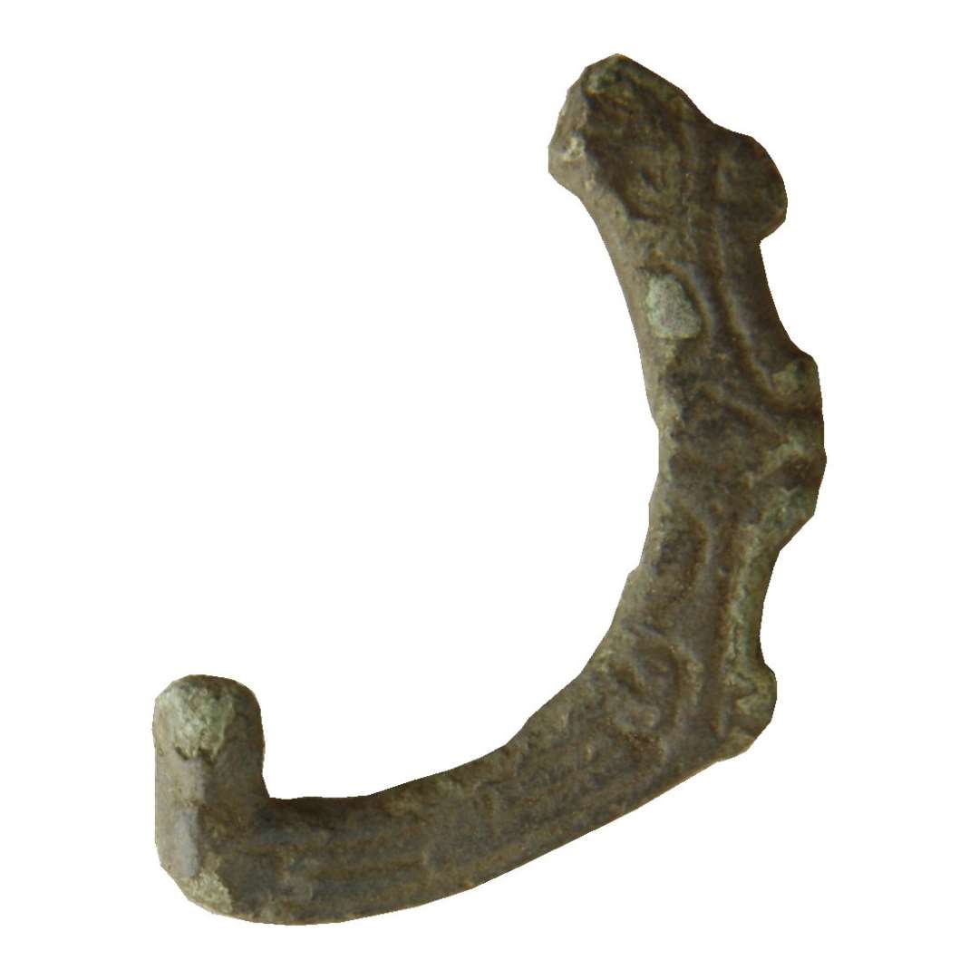 Fragment af bæltespænde med vikingetidsornamentik. Tre små flige ses på forkanten. Højde: 40 mm., bredde: 27 mm.