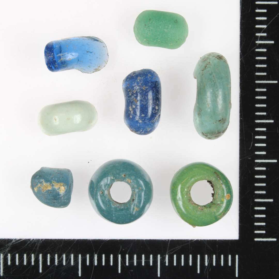 1 hel blå, 1 hel grøn, 1 halv af blåt glas, en halv af grønt glas, en halv af opak hvidt glas og 3 fragmenter af blåt glas. 