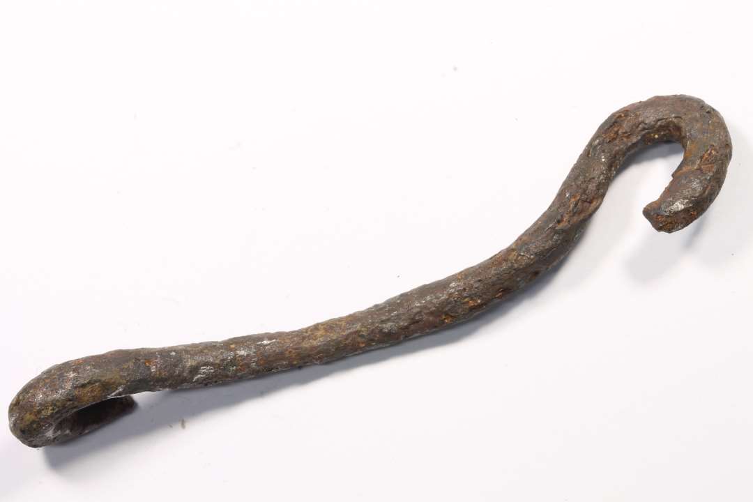 Et 8,5 cm langt, buet stykke jern med krog i hver ende. Funktion og datering ukendt. 