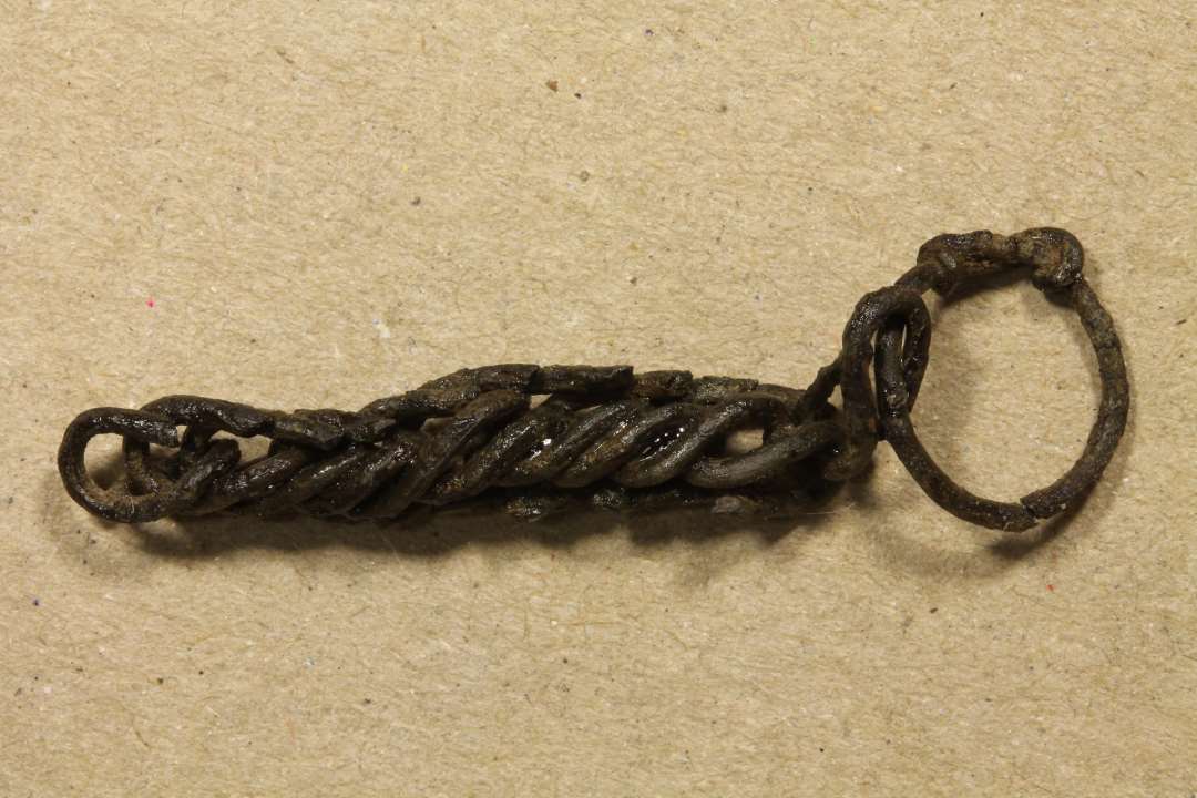 Fragment af kæde flettet af ringe. Længde: 4cm.