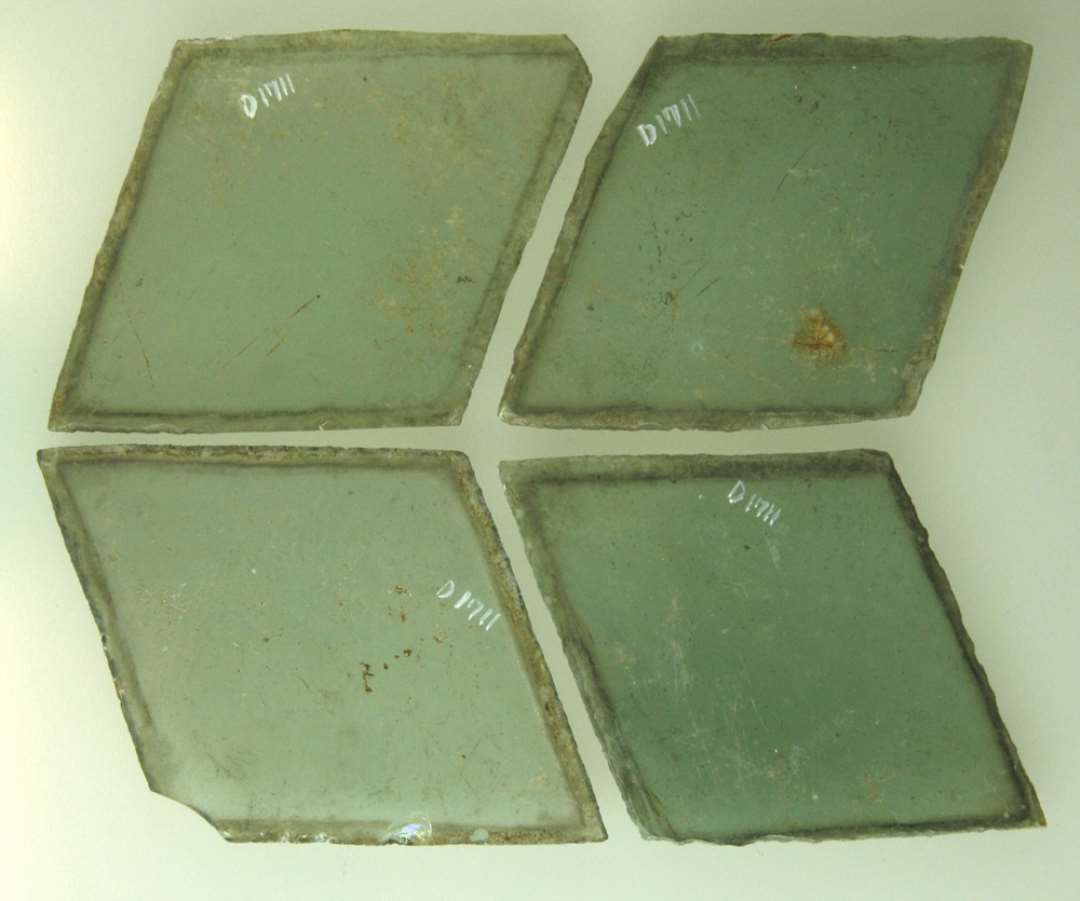 4 hele ruder af grønligt glas med afnappede kanter, ruderne har rhombeform med en sidelængde på ca. 6,5 cm. Største længde: 10,5 - 10,3 - 10,2 - 10 cm. Største bredde: 6,9 - 7,1 - 7,5 - 7,25 cm.