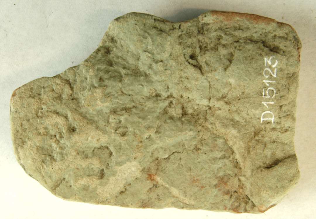 1 fragment af sandsten, gråligt med rødlige striber. Største mål: ca 10 cm.
