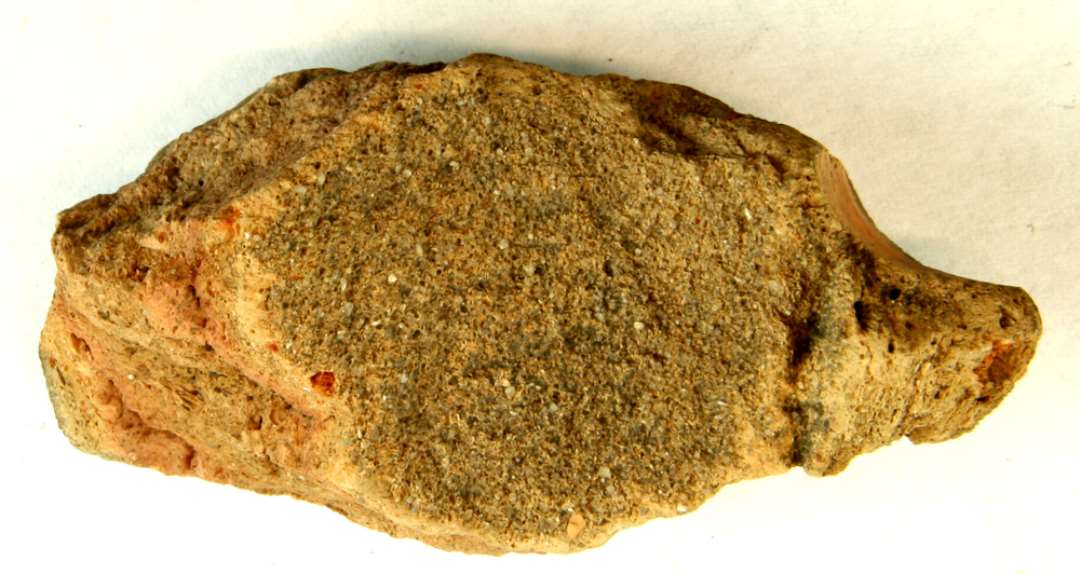 1 fragment af en middelalderlig tagsten af rødbrændt ler. Største mål: 8,5 cm.
