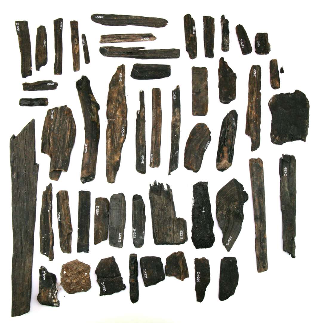 49 tildels sammenlimede fragmenter i form af afspaltede træstykker (det længste godt 28 cm.) og hugspåner, utildannede grendele, småpinde og træstumper samt barkstykker.