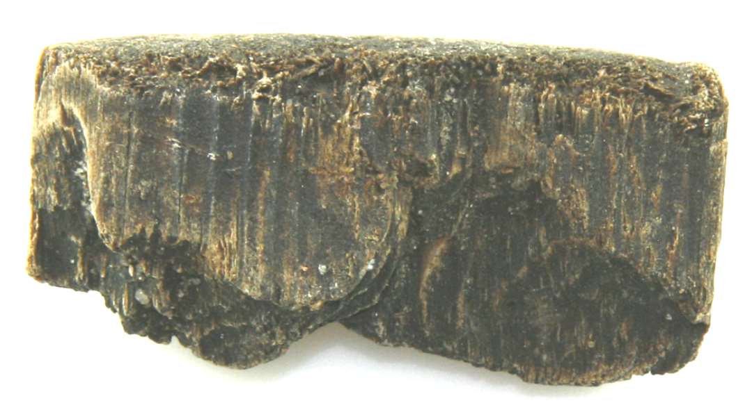 Træfragment, der udgør den nedre ende af tønde- eller kar stav af fyrretræ, afbrudt i den indskårne rille, hvori bunden har været indfældet. Stavens standflade er stærkt afrundet af slid. Fragmentets bredde: 5,6 cm. Fragmentets højde: 2,8 cm. Fragmentets tykkelse: 1,5 cm.