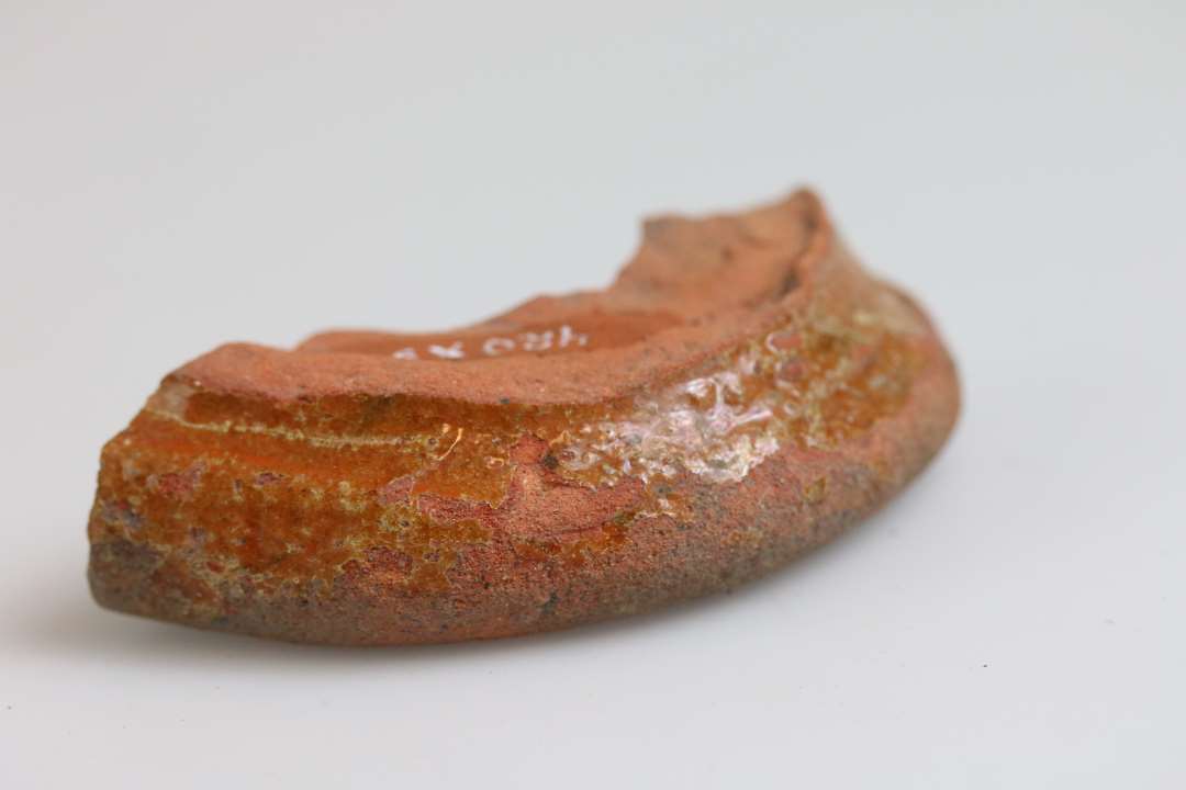 1 fodparti af rødbrændt kande eller muligvis lysestage med glat, drejet fodrand og klar blyglasur, B1