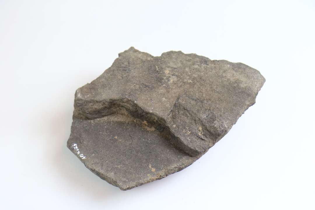1 afsprængt, ildskadet granitsten, muligvis rest af kværn? Mål: ca 20x14,5 cm., tykkelse: ca 4,5 cm.