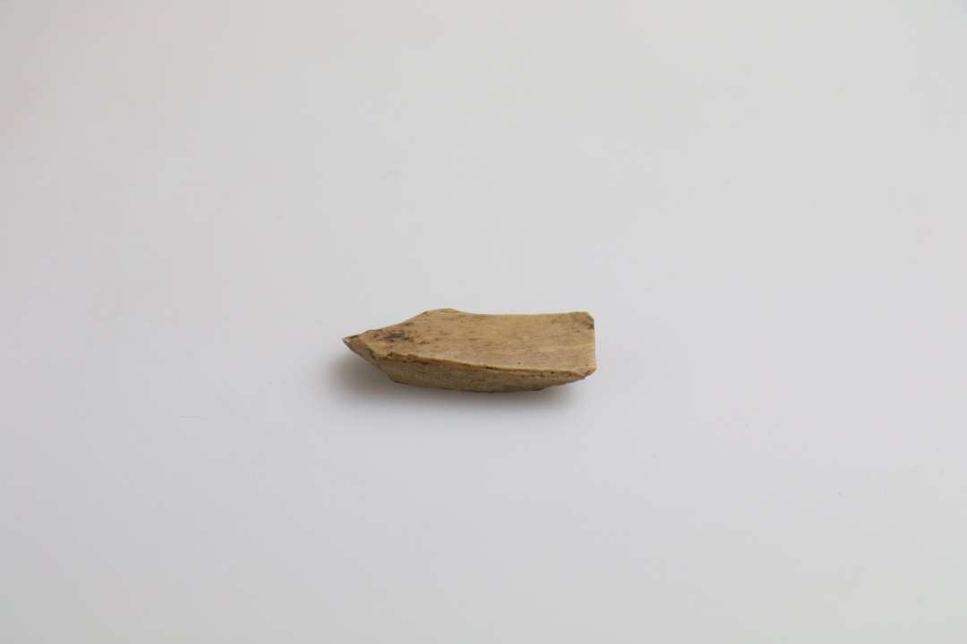 1 kantfragment af meget fint hvæssesten af brunligt kalksandsten Længde: 3,6 cm. Bredde: 1,2 cm.