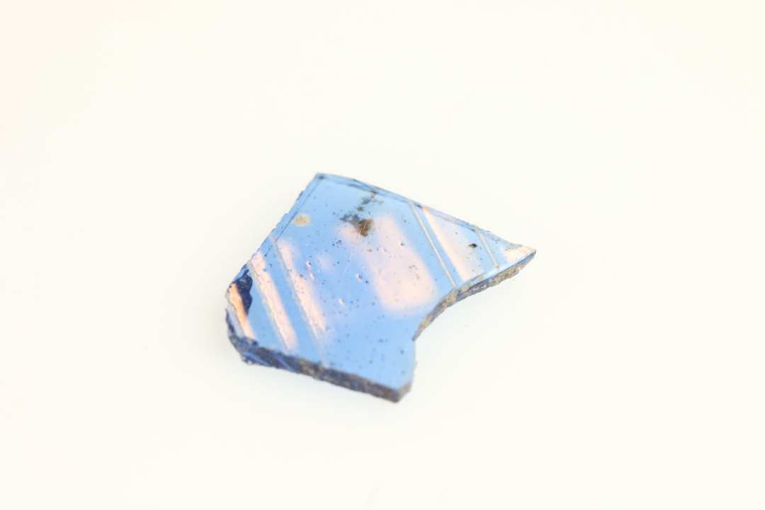 Et stykke blåt, genemsigtigt glas med hvide striber
