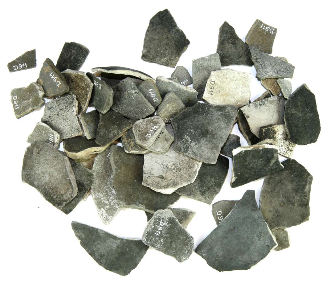 56 bund- og bugskår af hårdtbrændt, grynet stentøjsagtigt gods, ofte med lysegrå skærv og grå til gråsort ofte sølvglansagtig overflade. Paffrath.