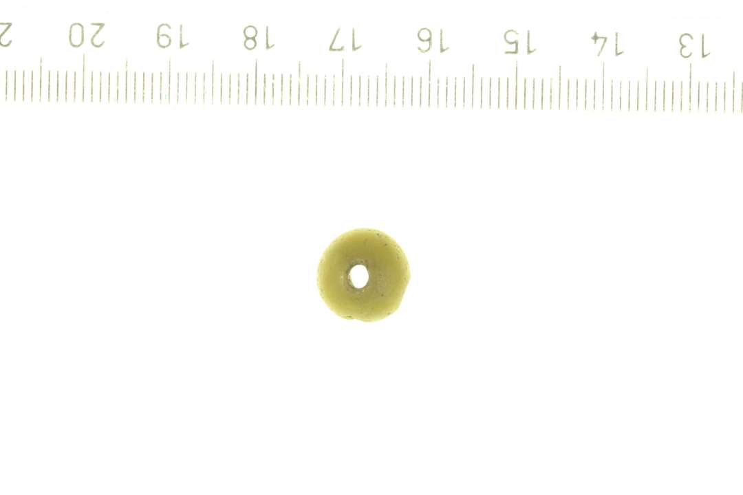 1 perle af gult glas, uigennemsigtig. D: ca 1 cm.