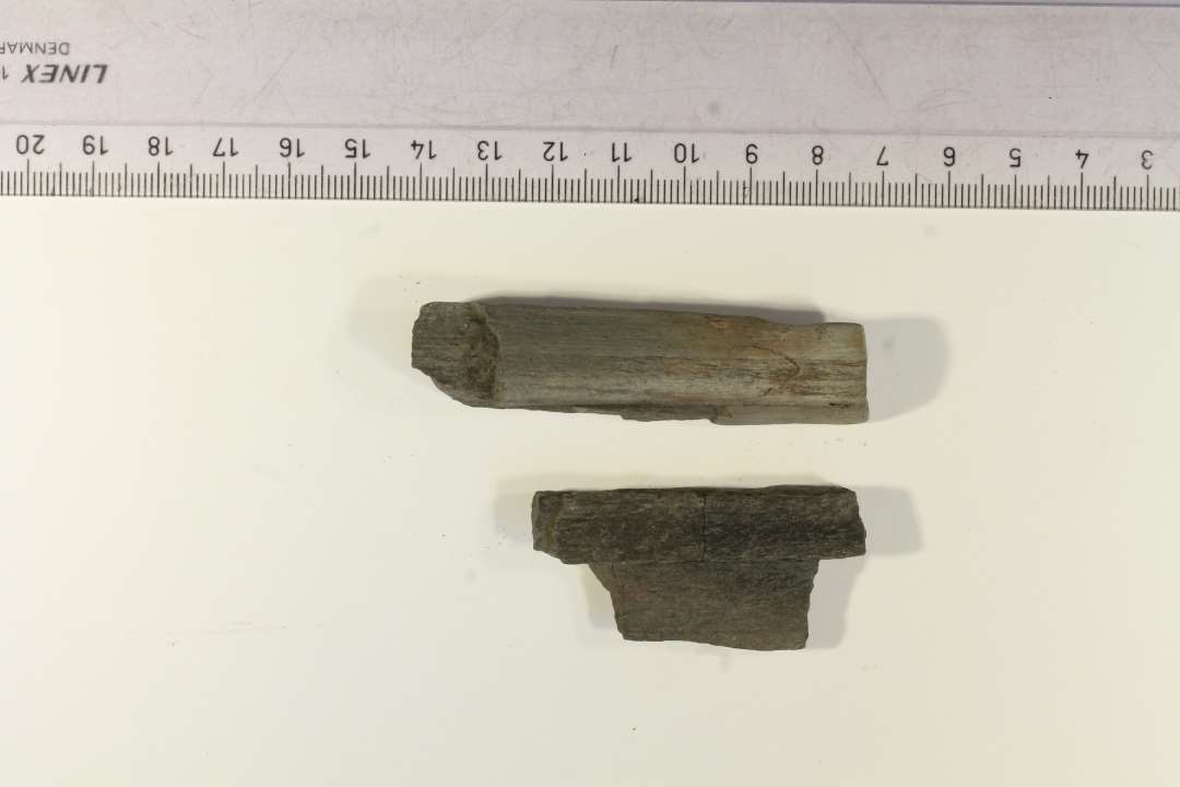 2 fragmenter af hvæssesten med sliberille. 