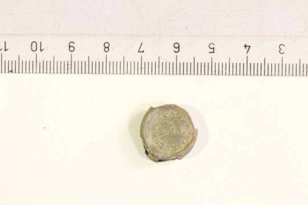 1 lille blyplombe KJØBENHAVN og COMPANIET .ENT...LMT. diameter: ca 1,5 cm. 