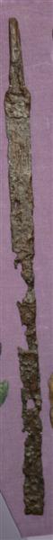 Fragment af jernsværd. Stærkt forvitret. Del af grebtungen med rektangulært tværsnit - bevaret, hvor klingen er bedst bevaret, viser den et tresidet tværsnit, og den har antagelig været en-ægget hele vejen. Spidsen afbrækket. Samlet længde: 62 cm. Grebtungens længde: 8,5 cm. Klingens største bredde: 3,2 cm.