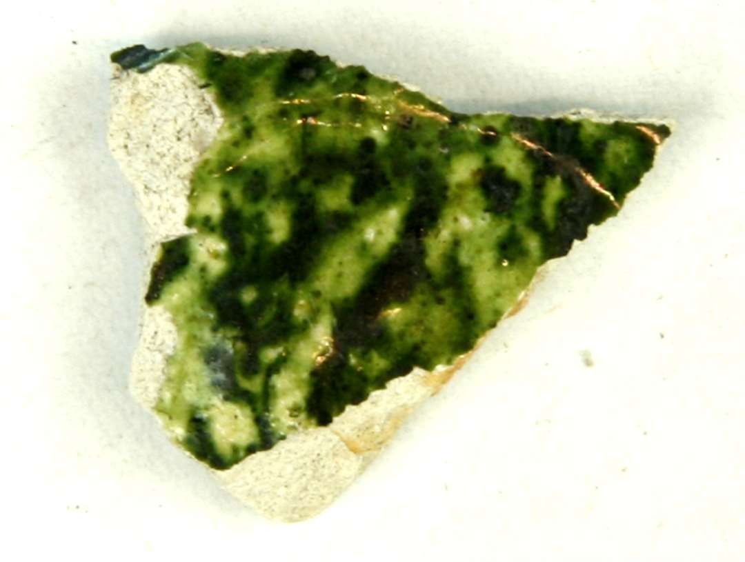 1 lille sideskår af pibelersgods med plettet grøn blyglasur på midter- og yderside. Gruppe 1.