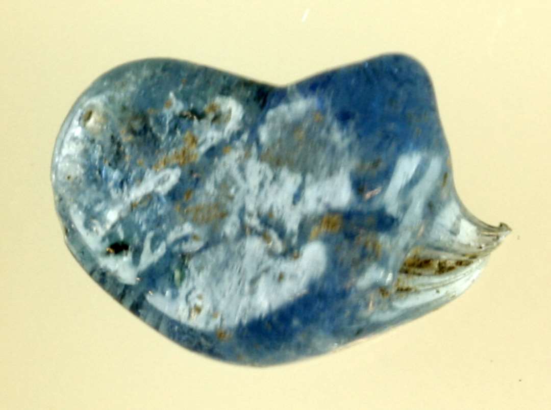 1 klump smeltet blålig gennemsigtig glasmasse af afrundet delvis sammenklemt form ( tangbid ), udtrukket i en spids i den ene ende.