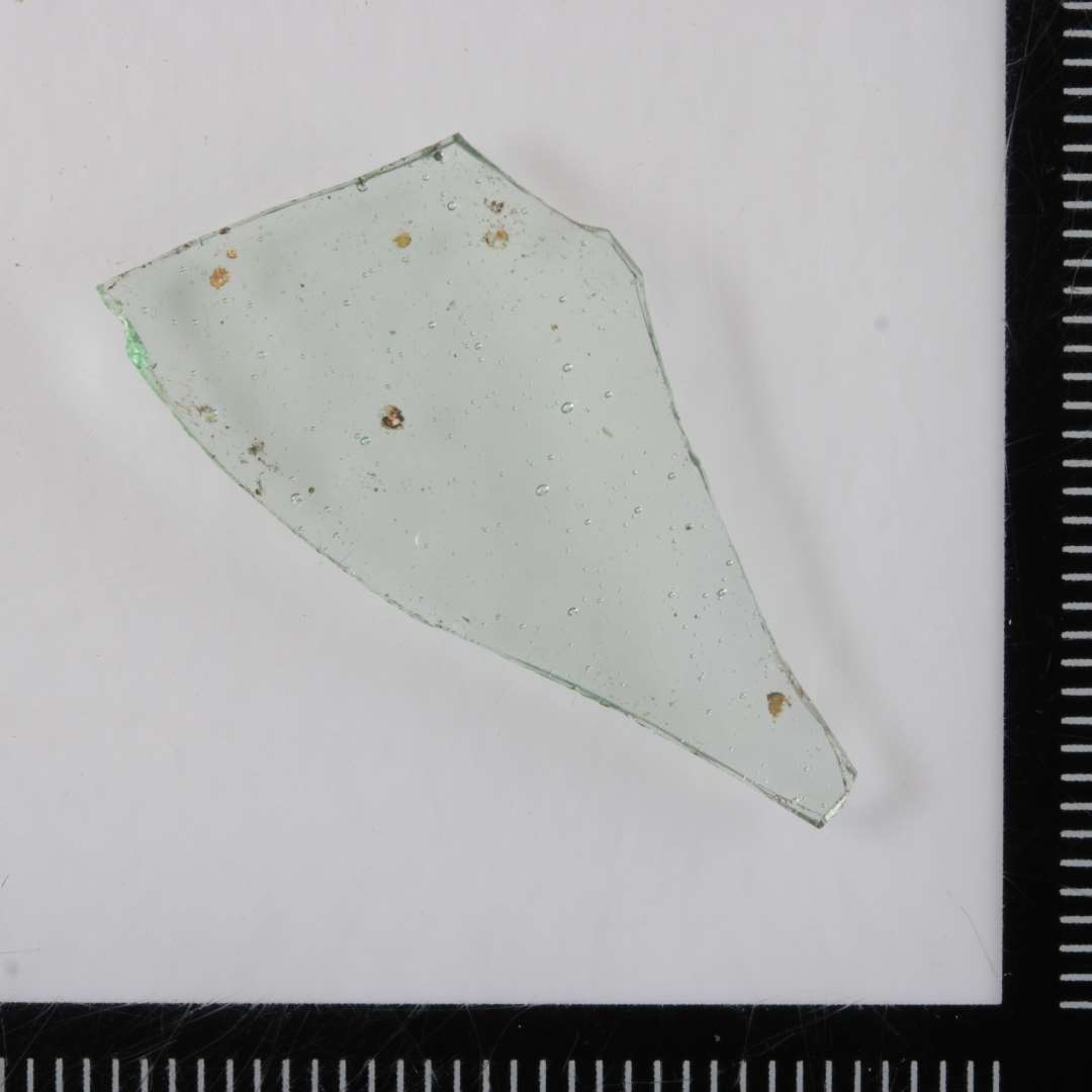 1 sideskår fra kar (bæger) af svagt grønligt gennemsigtigt glas.