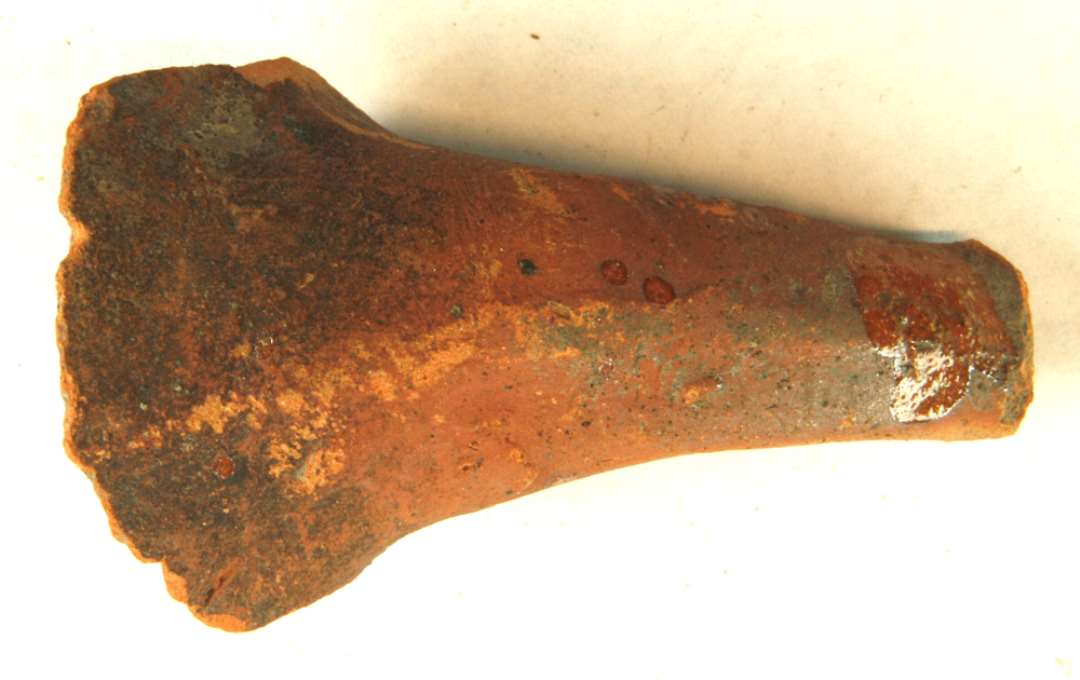 1 stjertpandehank af rødbrændt lergods med klar blyglasur på indersidepartiet og pletvis på overfladen. Gr. 1.