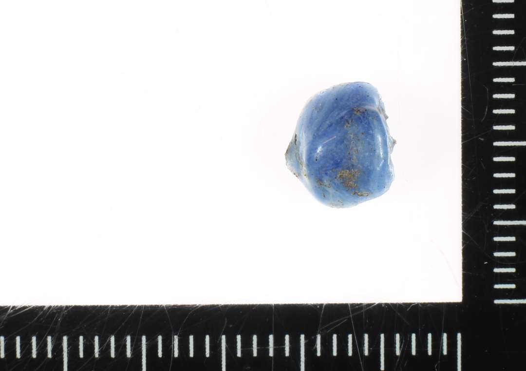 ½ perle af ujævn afrundet cylindrisk form og af blåhvidmeleret ugennemsigtigt glas. 8 mm.