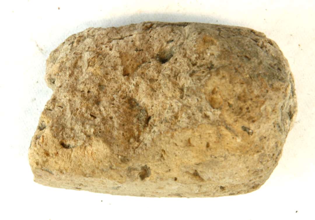 1 fragment af discosformet vævevægt (?) af gråbrunlig lermasse. Mål: 6 cm.