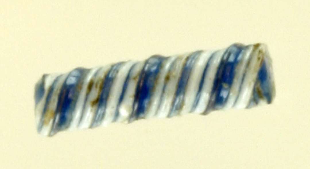 1 stump snoet glastråd bestående af blålig gennemsigtig glasmasse udenpå hvilken der er snoet to tæt anbragte tråde af hvidgråt, ugennemsigtigt glas.