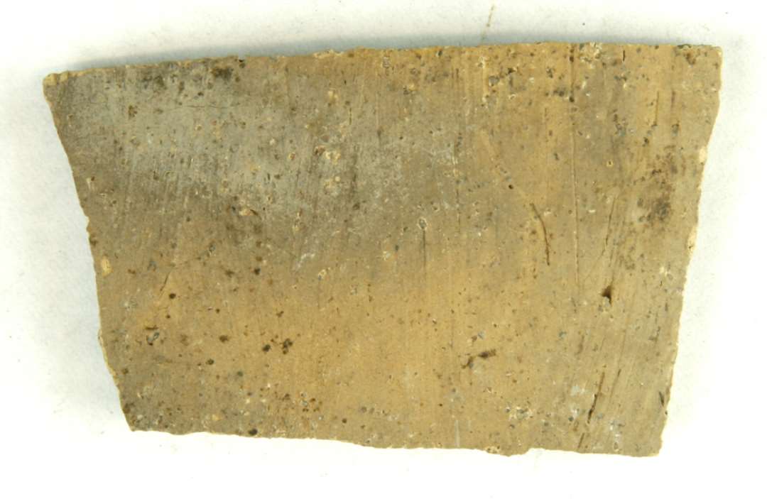 1 sideskår af gulliggråt, magret, porøst lergods. Gr. 8 (10).