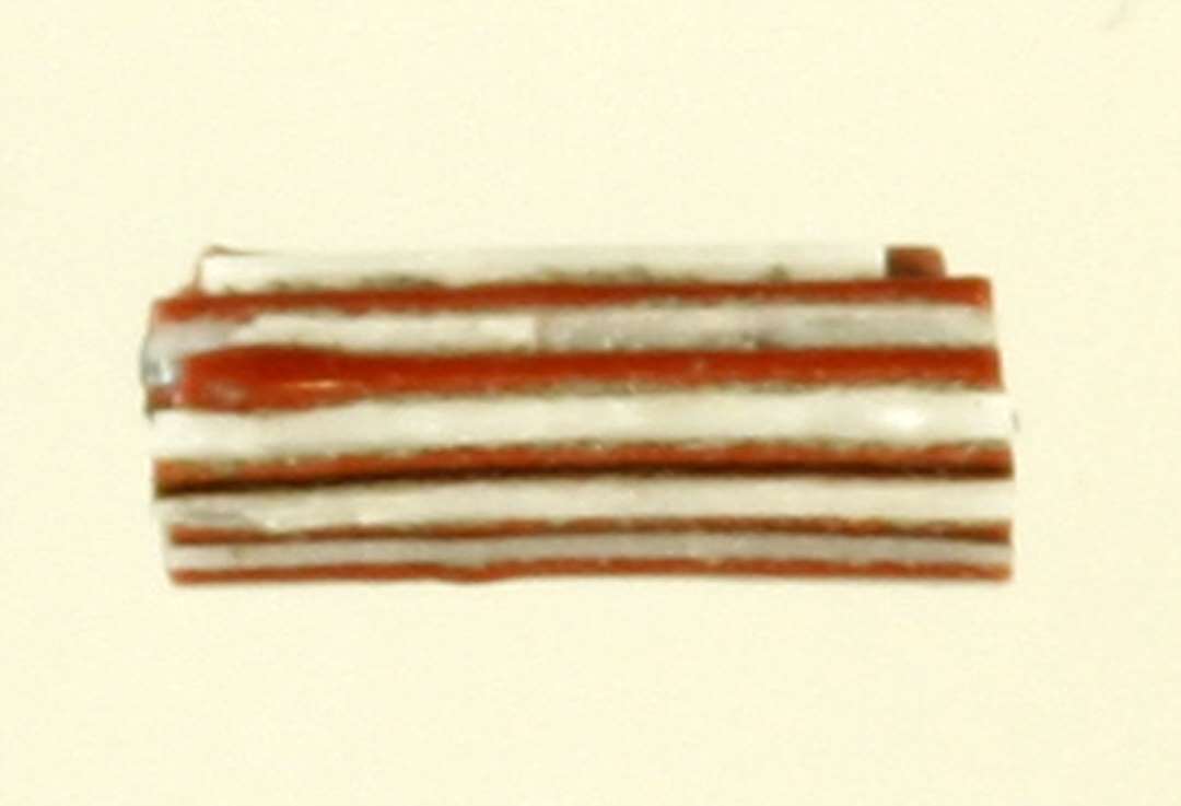 1 fragment af glasstang med cirkulært tværsnit dannet af en kærne af blåligt gennemsigtigt glas omgivet af et lag af tynde tråde af ugennemsigtig afvekslende rød og hvid glasmasse.