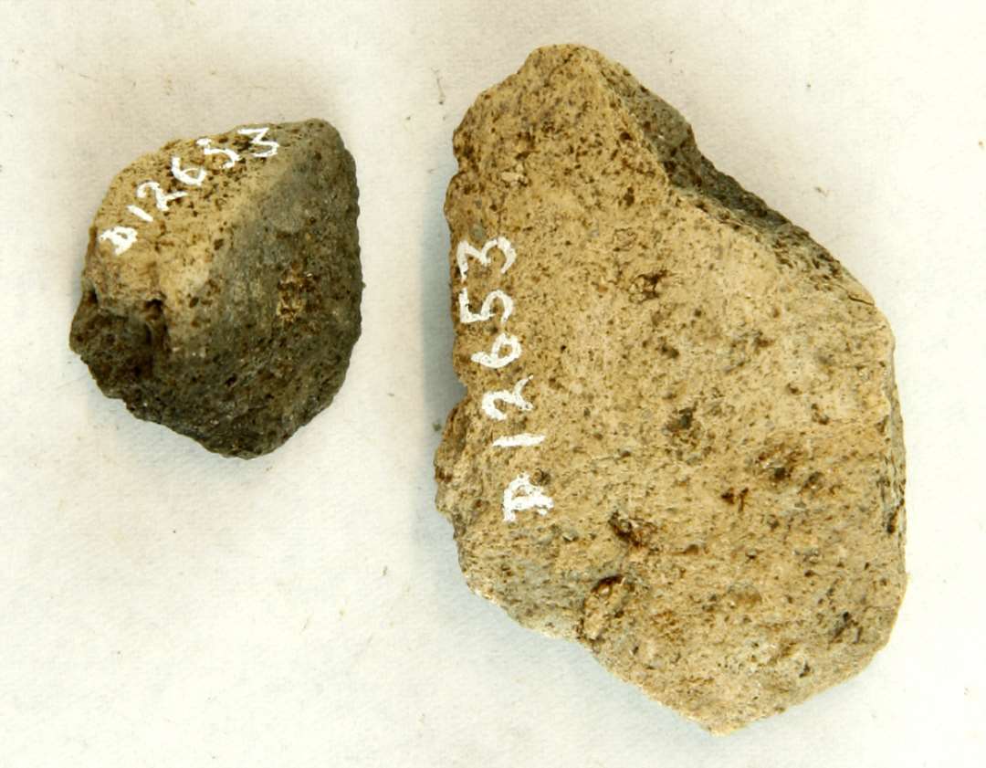 2 fragmentstumper af discosformet vævevægt. Mål: 2,5-5,5 cm.