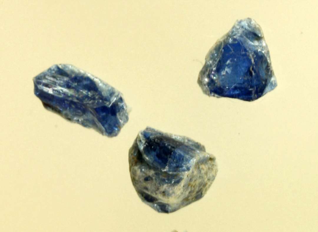 3 ubetydelige stumper af smeltet ærtestor klump af blåligt gennemsigtigt glas.