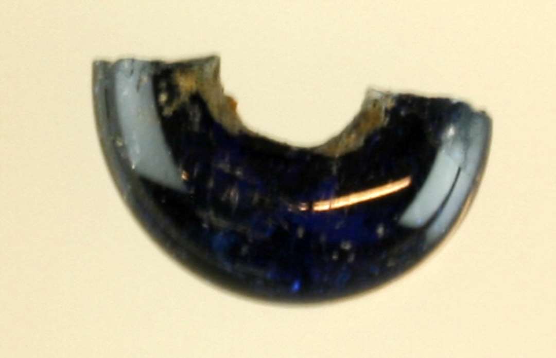 ½ perle af afrundet ringform af dybblåt gennemsigtigt glas.
