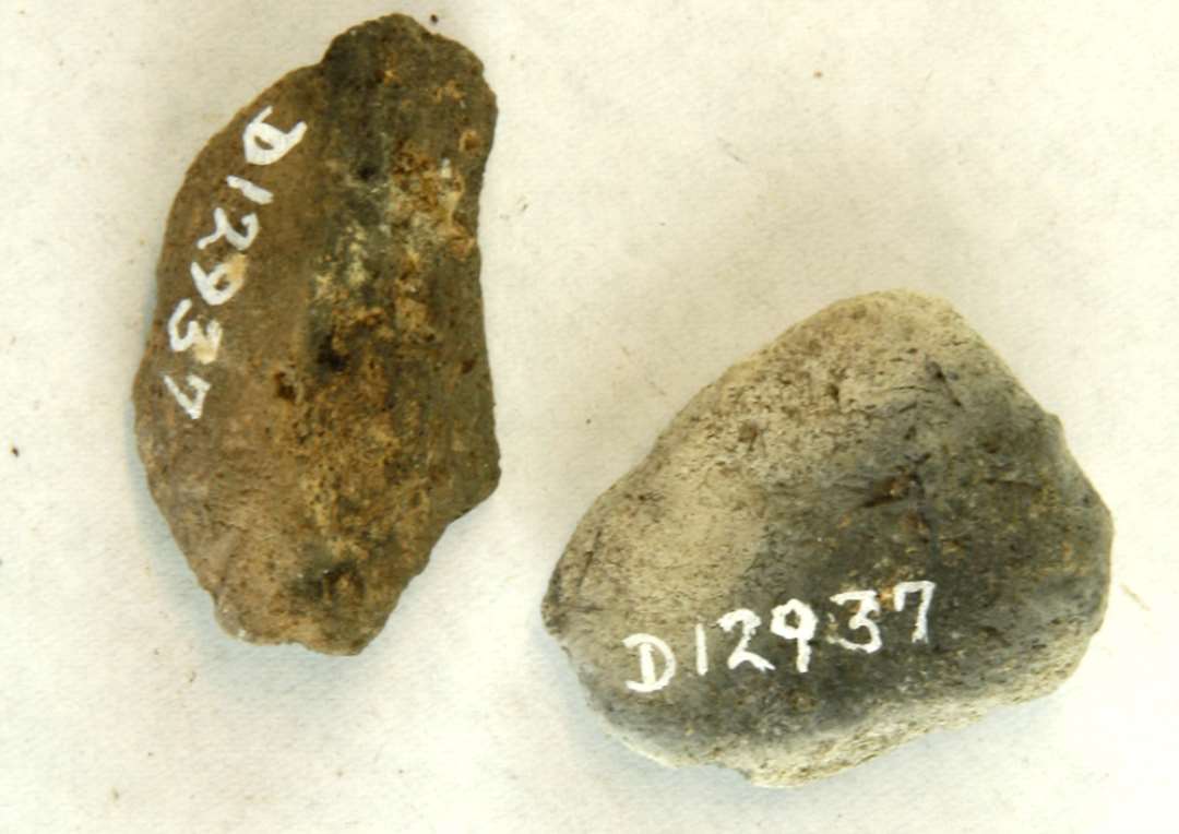 2 stumper af discosformede vævevægte af brændt ler. Mål: 3,5-4,5 cm.