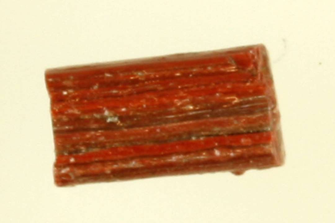 1 stump af glasstang med kvadratisk tværsnit af rødbrunlig ugennemsigtig glasmasse.