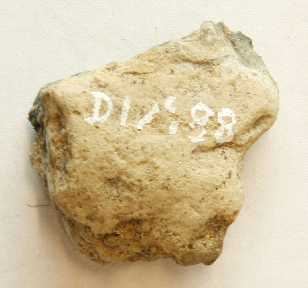 1 delvis sintret fragment af støbeform(?) af brunlig, porøs, glimmerblandet brændt lermasse. Mål: 3,5 cm.