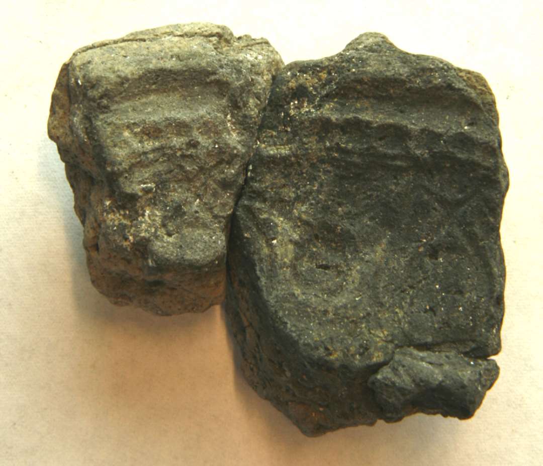 AMR 1 randfragment af støbeformshalvdel af brændt ler med ornamentspor på indersiden. Mål: 3,5 x 3,0 cm. Sammenlimet med D10454.