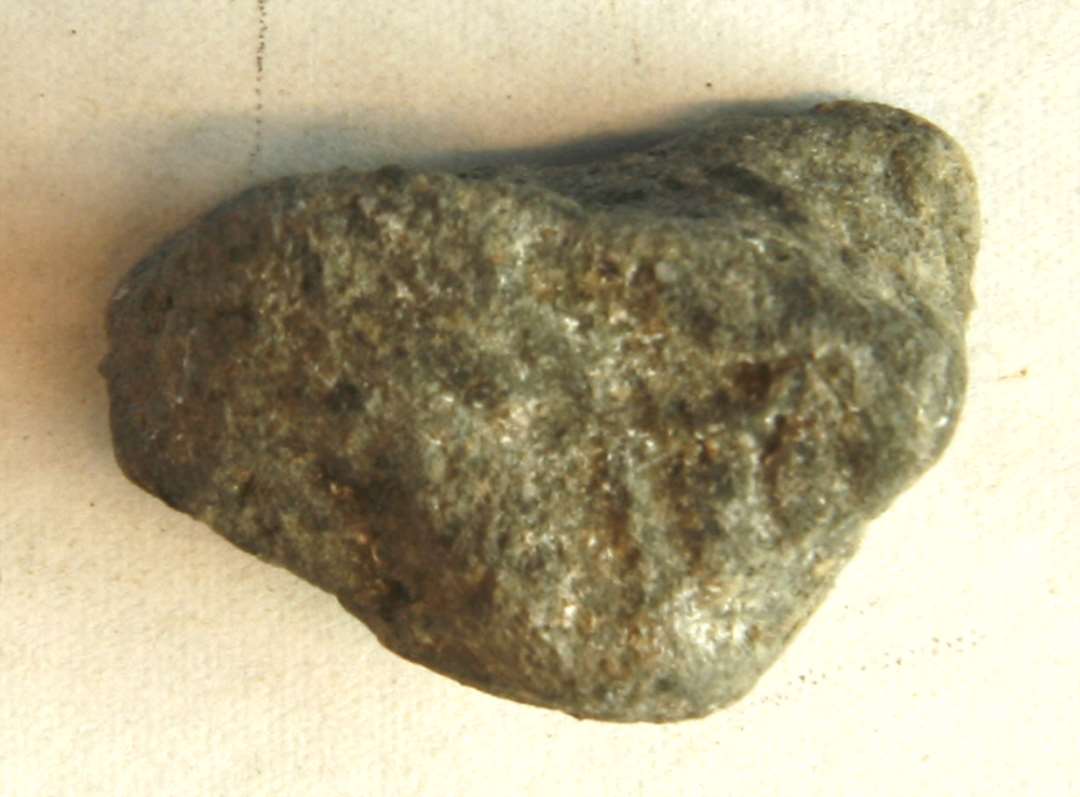 ANB 1 fragment af støbeform af gråbrændt ler med en delvis plan flade med en fure. Mål: 2,5 x 2,3 x 1,4 cm. 