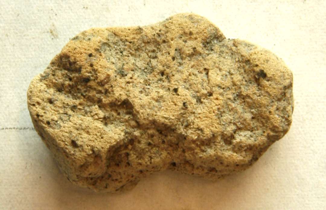 1 støbeformsfragment af brunlig brændt lermasse. Mål: 3,1 x 2,9 x 1,25 cm.