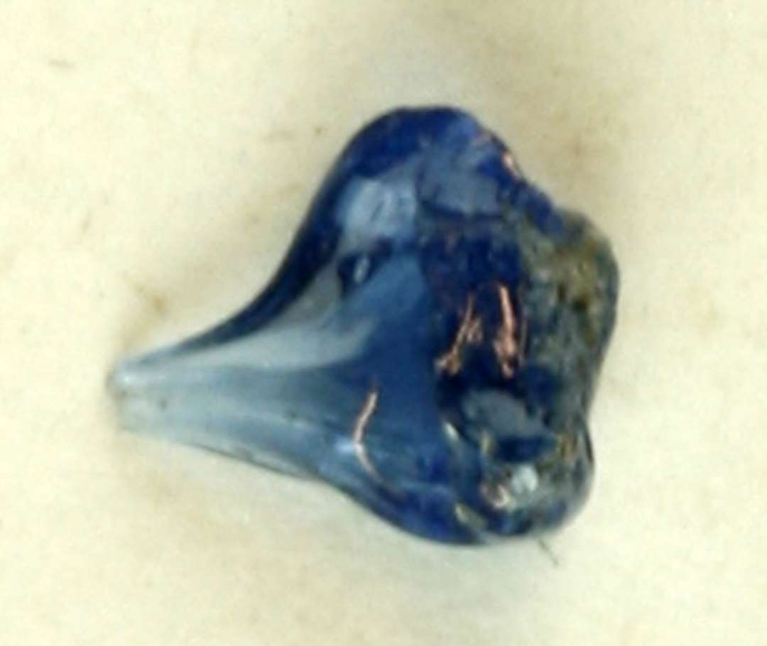 1 fragmentstump af smeltet gennemsigtigt blåligt glas udtrukket i en tynd spids i den ene side.