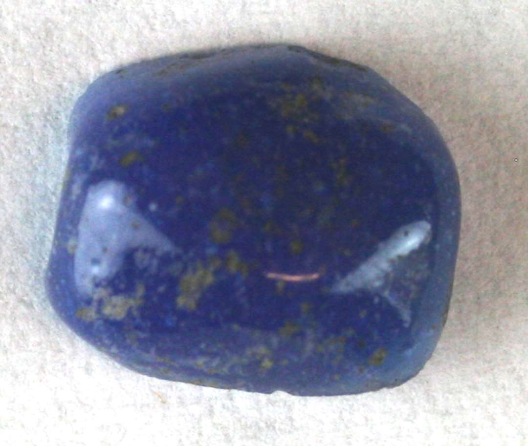 ½ perle, spaltet på langs, af cylindrisk form med facetteret overflade af blåligt, delvis gennemsigtigt glas. 10 mm.