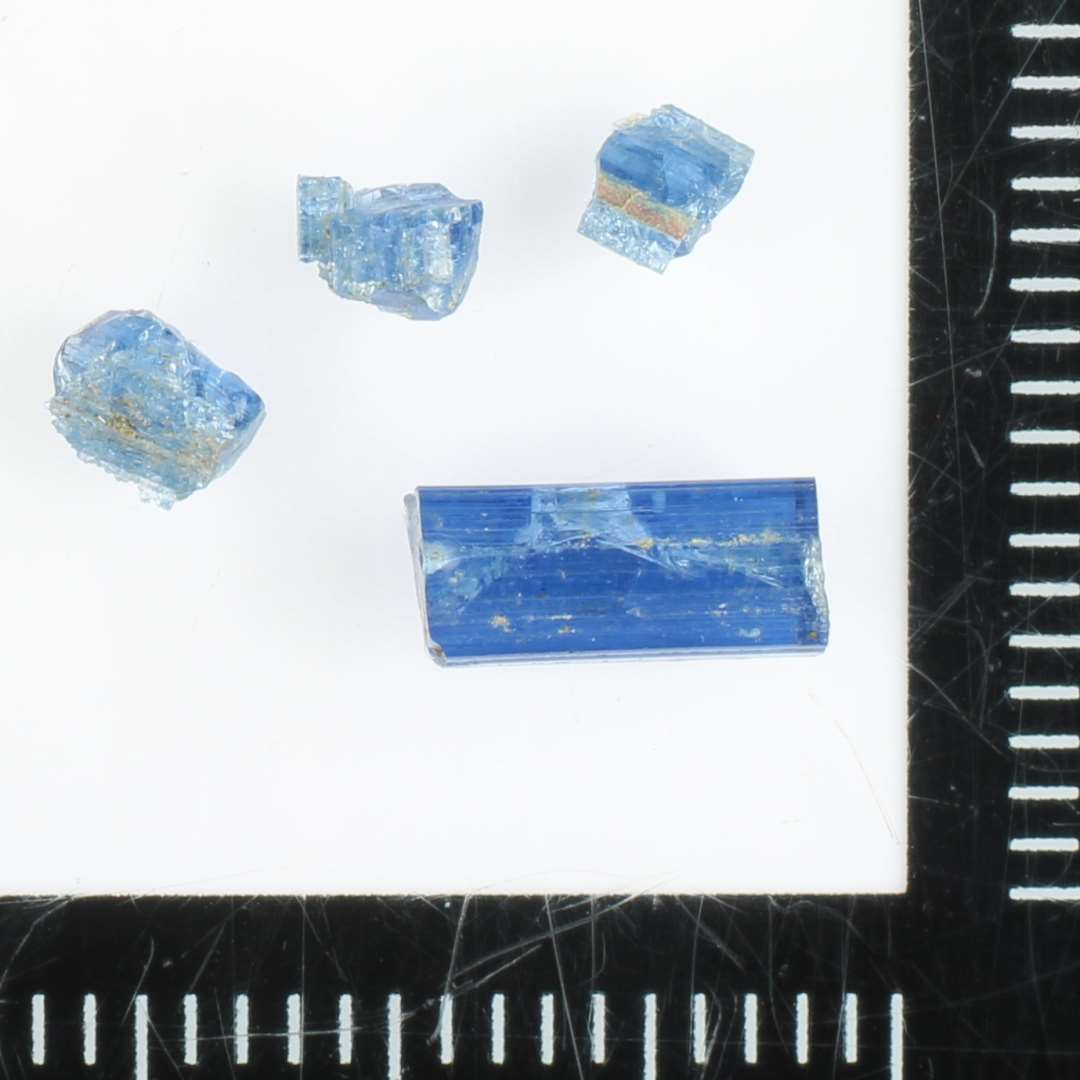 2 brudstykker af glasstænger af noget skæv, kvadratisk tværsnitsform af blålig gennemsigtig glasmasse.