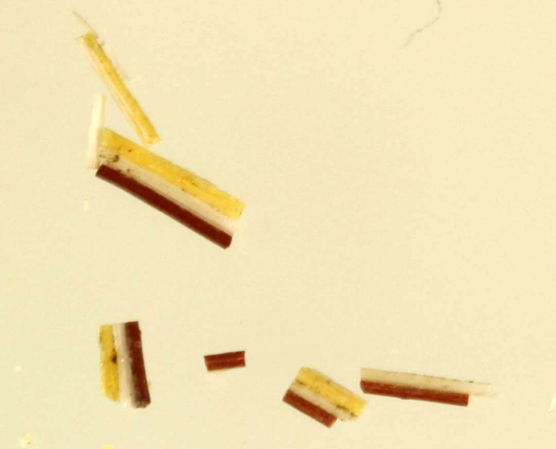 2 brudstykker af tynde, flade glastråde dannet af sammensmeltede tråde af rødbrunlig, hvidgrå og gullig ugennemsigtig glasmasse.