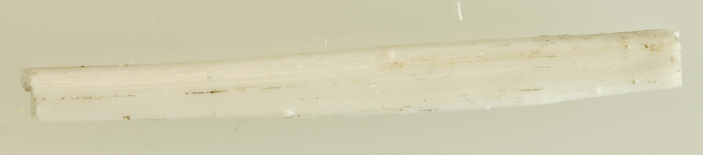 1 glasstang af hvidgår ugennemsigtig masse af kvadratisk tværsnitsform med let tilspidsning mod enderne. L: 5,2 cm. St. tværmål: 0,55 x 0,55 cm.
